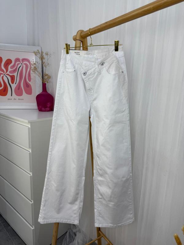 pantalón blanco vaquero con los botones asimétricos